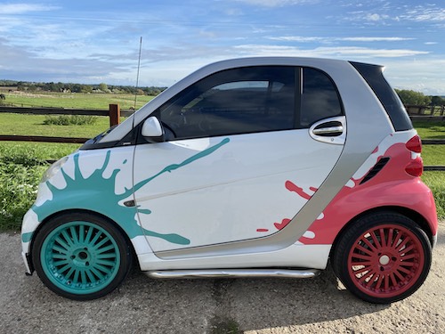 White Smart Car with custom paint job with blue and pink splats