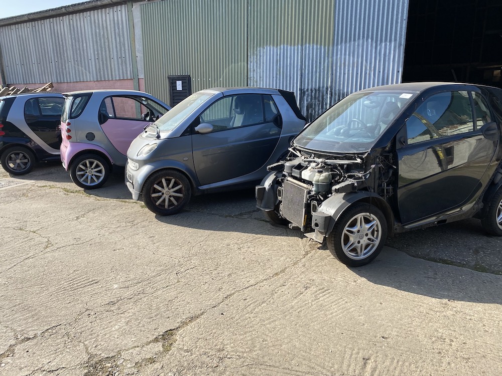 Smart Cars parked in a row. Spares or repairs.